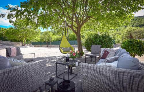 a patio with wicker chairs and a hammock under a tree at Villa Silentio Dalmatia in Makarska