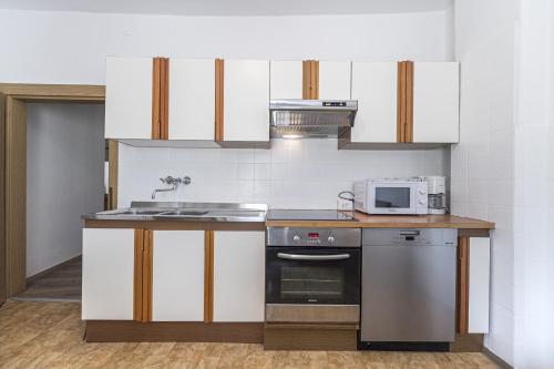 a kitchen with a sink and a stove at Central Apartments Cristlpek in Ortisei