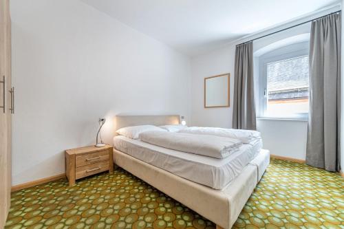 a bedroom with a large bed and a window at Central Apartments Cristlpek in Ortisei