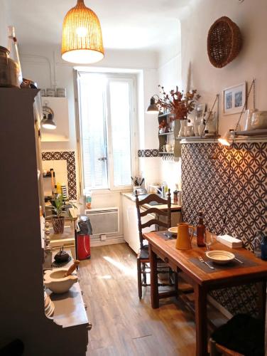 une cuisine avec une table et des chaises dans une pièce dans l'établissement Chez l'habitant, propose Grande chambre Vieux port Marseille, à Marseille