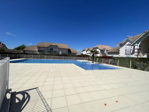 - une piscine dans une cour avec des maisons dans l'établissement Charmante Maison de Vacances avec Piscine, Proche Plage et Commerces - FR-1-324A-43, à Notre-Dame-de-Monts