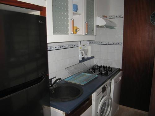 małą kuchnię ze zlewem i pralką w obiekcie Appartement 3 pièces avec clim, wifi, parking Saint-Cyprien Plage - FR-1-106-62 w mieście Saint-Cyprien