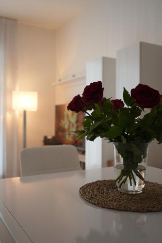 um vaso de rosas sentado numa mesa em La Mia Casa Romana em Roma