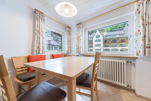 a dining room with a table and chairs and a window at Central Apartments Cristlpek in Ortisei