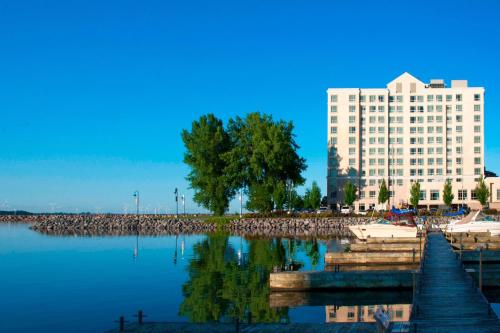 a large white building with a tree in the water at Residence Inn by Marriott Kingston Water's Edge in Kingston