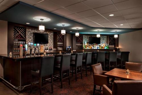 a bar in a restaurant with chairs and tables at Delta Hotels by Marriott Sault Ste. Marie Waterfront in Sault Ste. Marie