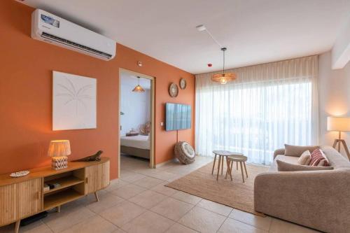 a living room with a couch and a table at NEW! Right at the Beach! Curazure Beach Condo, Jan Thiel in Willemstad