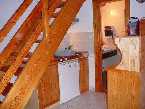 a kitchen with a wooden staircase with a white dishwasher at Zöld sziget Apartmanház in Gyenesdiás