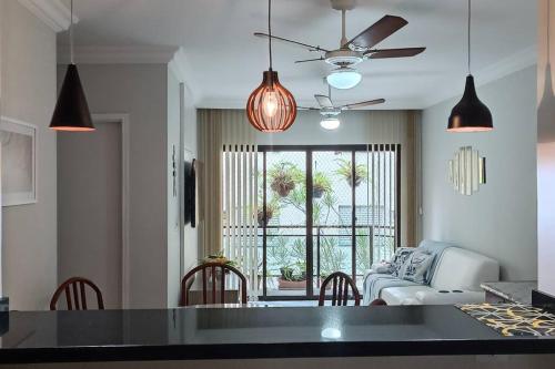 ein Wohnzimmer mit einer Couch und einem Tisch mit Stühlen in der Unterkunft Apartamento em Enseada - Guarujá in Guarujá