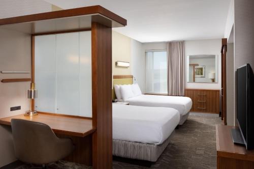 a hotel room with two beds and a desk and a television at SpringHill Suites by Marriott Grand Junction Downtown/Historic Main Street in Grand Junction