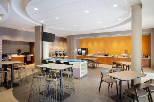 a restaurant with tables and chairs and a counter at SpringHill Suites by Marriott Grand Junction Downtown/Historic Main Street in Grand Junction