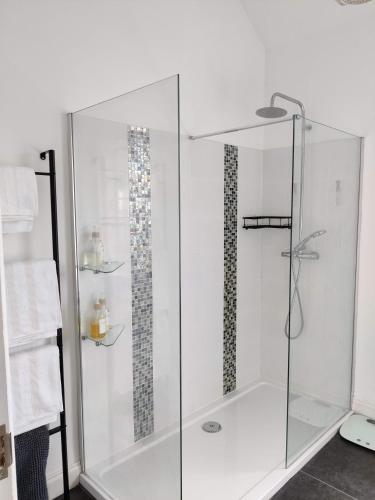 a shower with a glass enclosure in a bathroom at The Old Rope Works in Woburn Sands