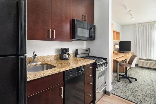a kitchen with a sink and a stove top oven at TownePlace Suites by Marriott Garden City in Garden City