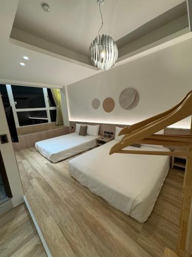 a bedroom with two beds and a chandelier at SMilE WAVE in Xiaoliuqiu