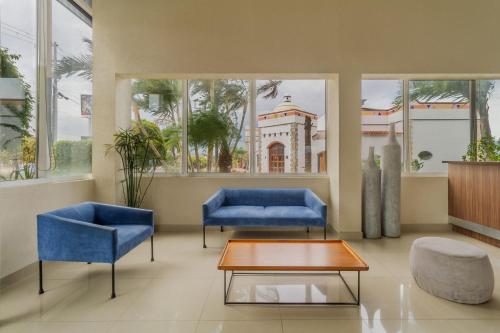 a lobby with two blue chairs and a coffee table at City Express by Marriott Tuxtla Gutiérrez in Tuxtla Gutiérrez