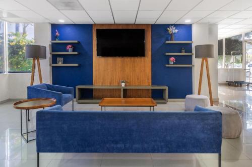 a waiting room with a blue wall and a tv at City Express by Marriott Tuxtla Gutiérrez in Tuxtla Gutiérrez