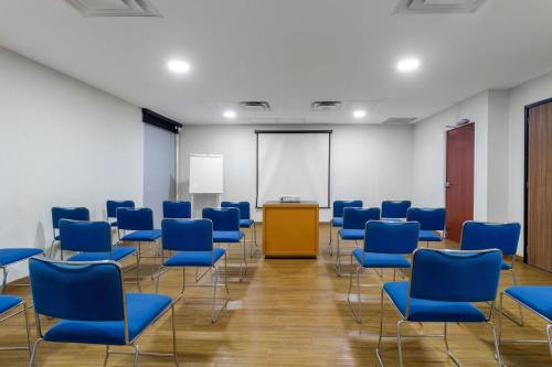 a conference room with blue chairs and a podium at City Express by Marriott Tuxtla Gutiérrez in Tuxtla Gutiérrez