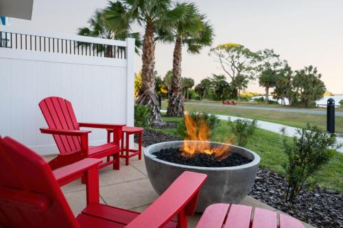 two red chairs and a fire pit on a patio at Courtyard By Marriott Titusville Kennedy Space Center in Titusville