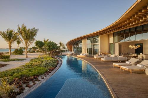 The St. Regis Red Sea Resort في Ḩanak: منتجع فيه مسبح بجانب مبنى