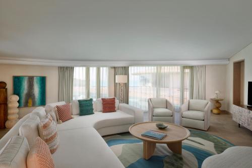 a living room with a white couch and chairs at The St. Regis Red Sea Resort in Ḩanak