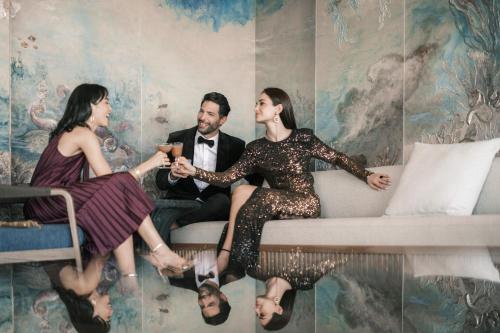 a group of three people sitting on a couch in a room at The St. Regis Red Sea Resort in Ḩanak