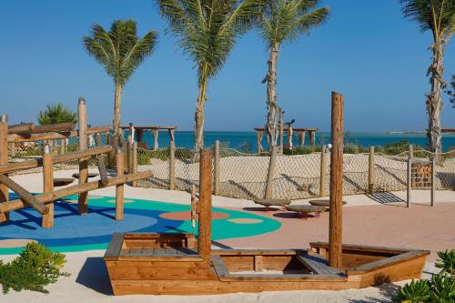 a playground on the beach with palm trees at The St. Regis Red Sea Resort in Ḩanak