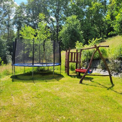 a playground with a trampoline and a swing at Chloumek in Bělá