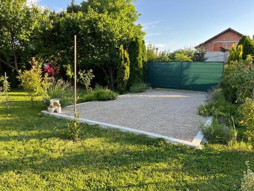 a garden with a gravel driveway with a fence at Petrovaradin Chalet in Novi Sad