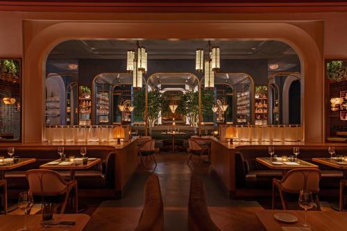 a restaurant with tables and chairs and a chandelier at JW Marriott Essex House New York in New York