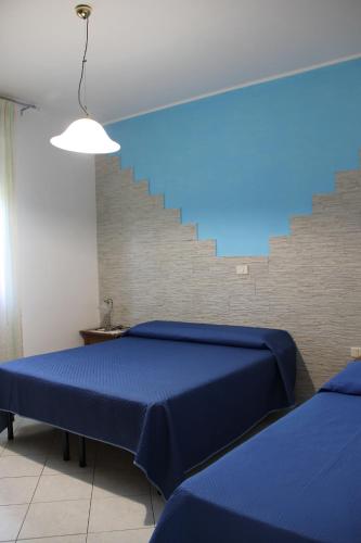 a bedroom with two blue beds and a staircase at La Casetta di Gabri in San Vito Chietino