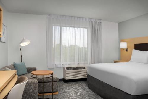 ゲインズビルにあるTownePlace Suites by Marriott Gainesville Northwestの大きなベッドとテーブルが備わるホテルルームです。