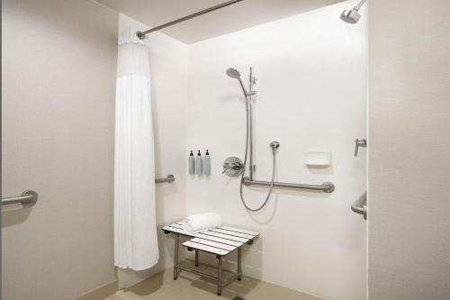 a bathroom with a shower with a bench in it at Courtyard by Marriott Los Angeles L.A. LIVE in Los Angeles
