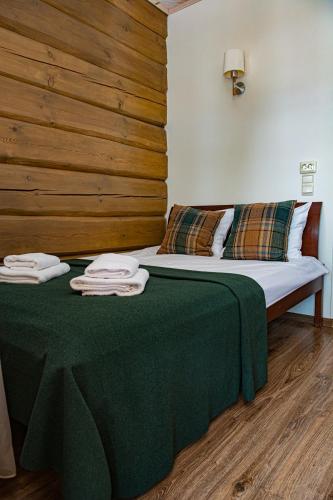 a bedroom with a bed with a green blanket at Porto Resort in Lilaste