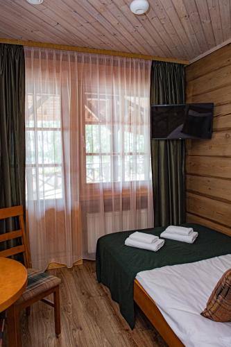 a bedroom with a bed and a table and a window at Porto Resort in Lilaste