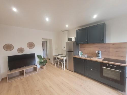 une cuisine avec des armoires noires et un comptoir dans l'établissement Le Coquillage, à Istres