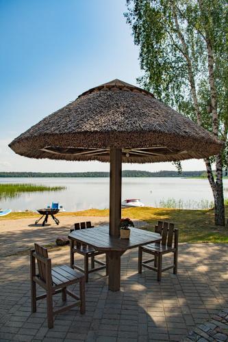 a picnic table with a large umbrella and two chairs at Porto Resort in Lilaste