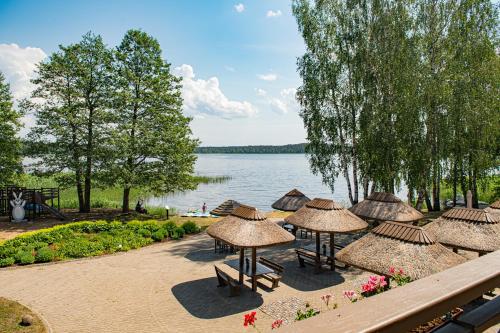 a group of tables and umbrellas next to a lake at Porto Resort in Lilaste