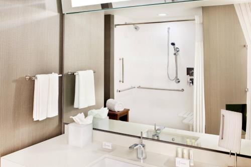 a bathroom with a sink and a shower at Courtyard by Marriott Yonkers Westchester County in Yonkers