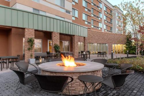 a fire pit in a courtyard with chairs and a building at Courtyard by Marriott Yonkers Westchester County in Yonkers