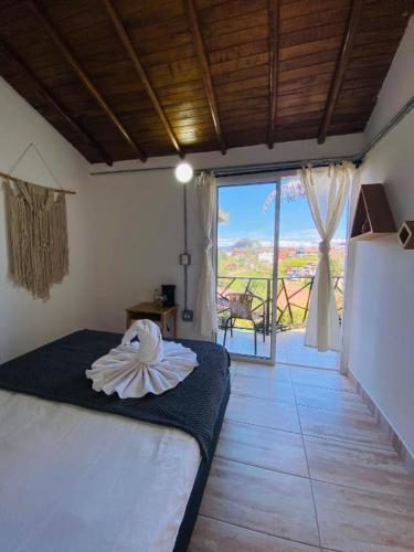 a bedroom with a bed with a view of a balcony at La Madriguera in Guatapé