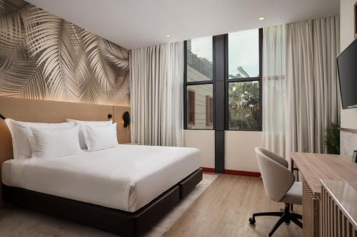 罗安达Protea Hotel by Marriott Luanda的配有床和书桌的酒店房间