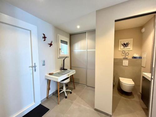 La salle de bains est pourvue d'un lavabo, de toilettes et d'un bureau. dans l'établissement Appartement haut de gamme vue mer classé 3 étoiles, à Cannes