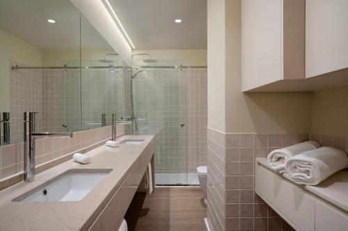 ein Badezimmer mit einem großen Waschbecken und einer Dusche in der Unterkunft Protea Hotel by Marriott Luanda in Luanda