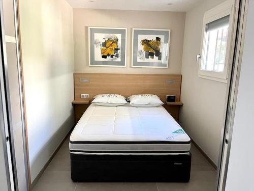 - un lit dans une chambre avec 2 photos sur le mur dans l'établissement Appartement haut de gamme vue mer classé 3 étoiles, à Cannes