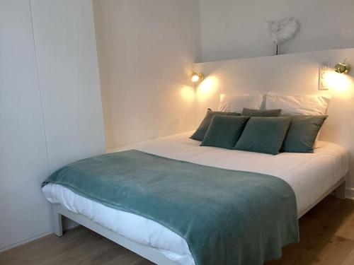 une chambre avec un grand lit avec des oreillers verts dans l'établissement Cocon chic parisien niché au cœur de Montmartre, à Paris