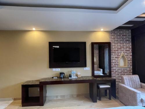 a living room with a television on a wall at Hotel Matina Suites in Pokhara