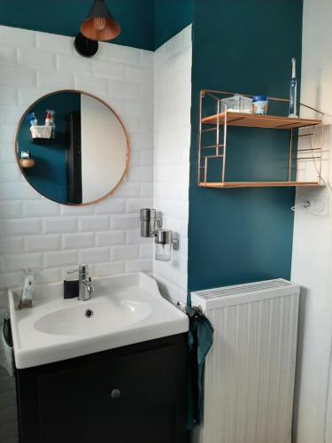 une salle de bain avec un lavabo et un miroir dans l'établissement Maison de ville front de mer, à Saint-Nazaire