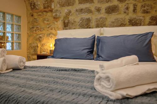 a bedroom with a bed with blue pillows and towels at La Fuga Luxury Experience in Santa Fiora