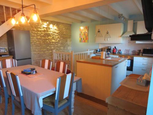 une cuisine et une salle à manger avec une table et des chaises dans l'établissement La Maison de Riviere, à Bourg-Charente