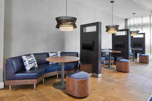 a lobby with a couch and tables and chairs at Courtyard by Marriott Atlanta NE/Duluth Sugarloaf in Duluth